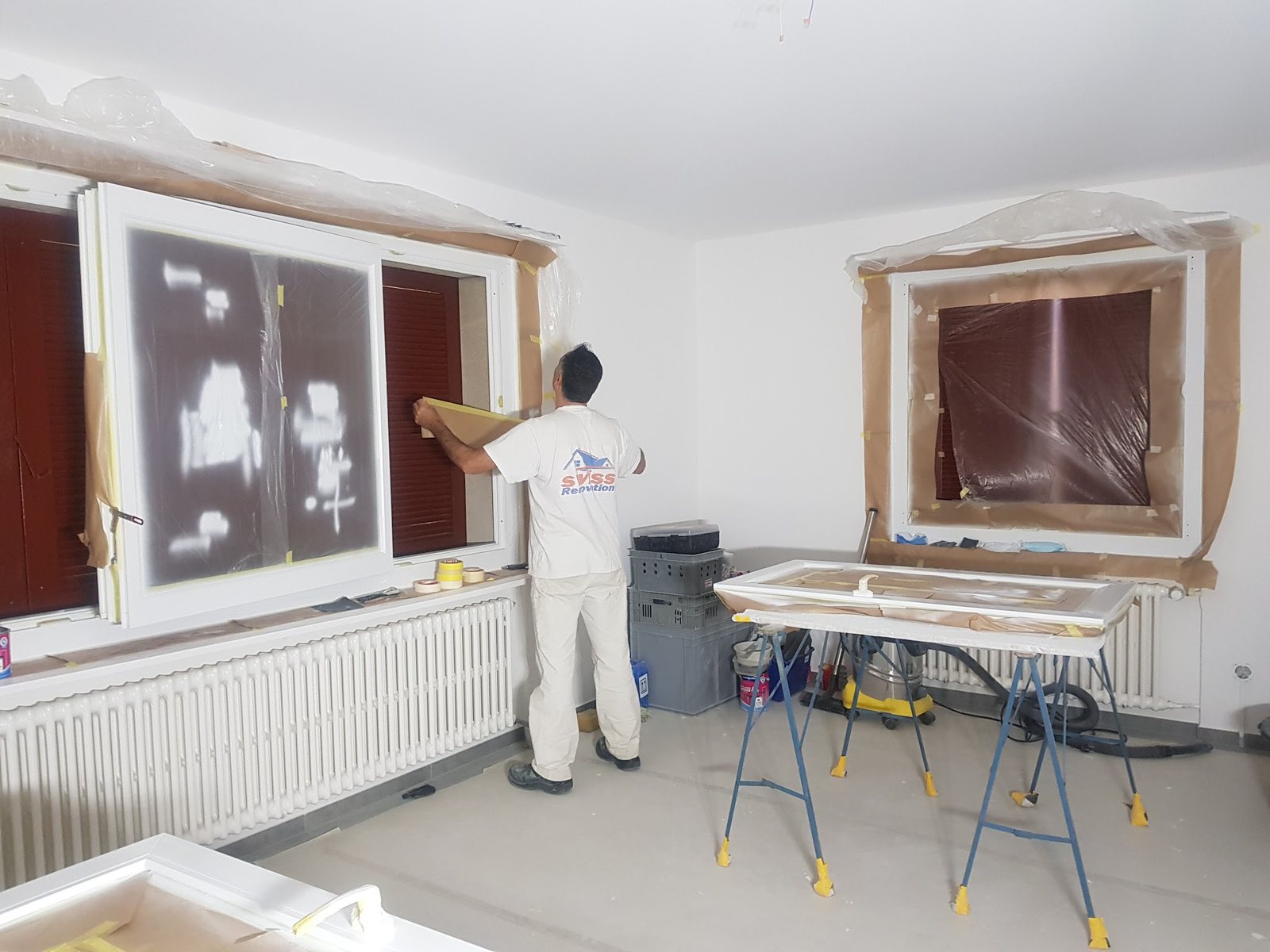 Mitarbeiter bei Abdeckarbeiten an einem Fenster