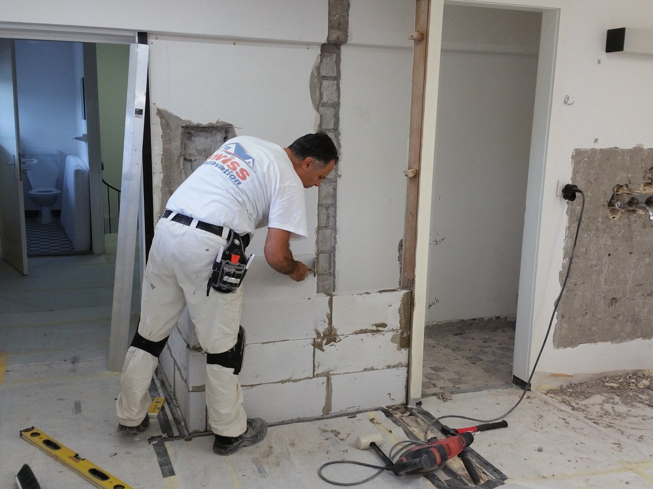 Mitarbeiter von Swiss Renovation bei Mauerarbeiten an einem Wanddurchbruch