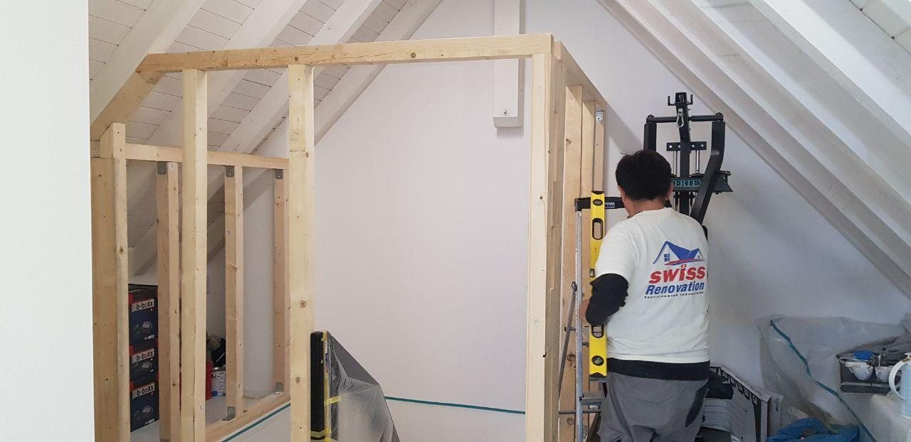 Mitarbeiter beim Trockenbau mit Holzständern im Dachgeschoss